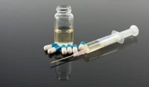 Syringe and Pills on a Table